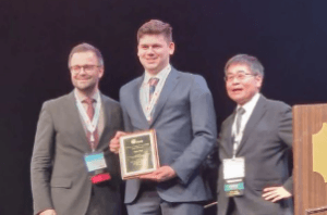 Taylor receiving the 2023 Asia Pacific Young Investigator Award in Dallas.